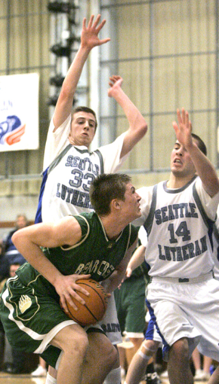 Bear Creek's Lucas Fernandez (No. 33) is guarded by Seattle Lutheran's Brian Simmons (No. 33) and Beau Severson (No. 14) as he heads to the basket during a game at Seattle Lutheran High School on Fri.