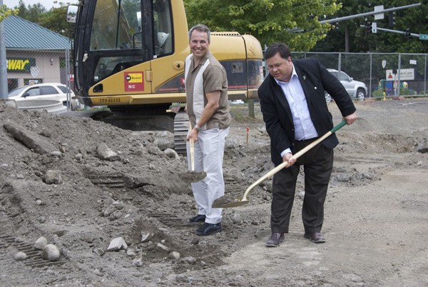 Dr. Howard Robinson (left) and City of Redmond Mayor John Marchione plow through the dirt at the groundbreaking for the new Brookfield Veterinary Hospital in Redmond.