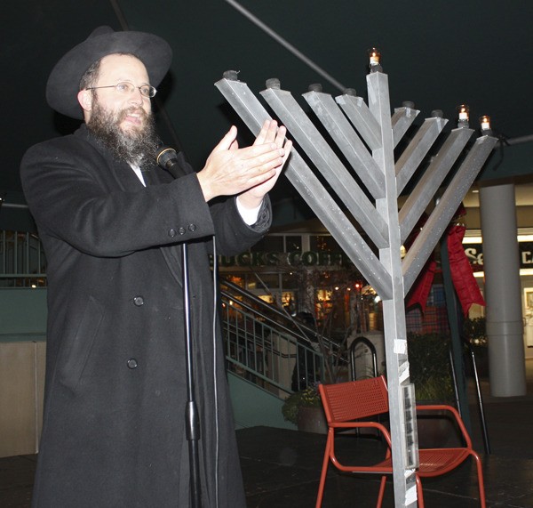 Rabbi Mordechai Farkash of the Eastside Torah Center leads the crowd at Redmond Town Center in a series of traditional Jewish songs during a public menorah lighting Wednesday evening