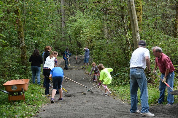Members of the Redmond Church of Jesus Christ and Latter-day Saints lay gravel down along the Powerline Trail in Redmond.