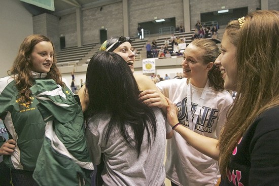 Redmond's Heather Harper gets a big hug from Kisa Isobe and congratulations from her teammates after taking first in the 100-yard breaststroke last Saturday at the state 4A swim meet at the King County Aquatics Center. Harper won the state title in 2008 and was narrowly out-touched at the wall last year by two hundredths of a second.