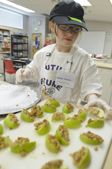 Rockwell Elementary School student Kaitlyn Marlow prepares apple crunch during the Kids Can Cook contest at Redmond Junior High School Wednesday.