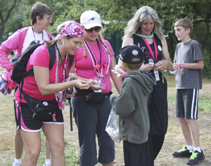Six-year-old Nicholas Kilian of North Bend passes out candy to Seattle Susan G. Komen 3-Day for the Cure participants at the Idylwood Park cheering station in Redmond. The event raised $5.3 million for breast cancer research and community-based education programs.