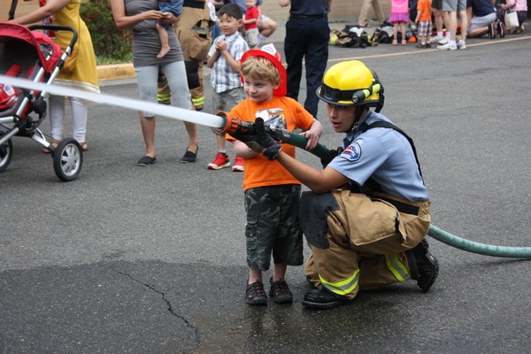 Redmond Fire Explorer Will Jarman (right) helps 4-and-a-half-year-old Nitsan Barenboim work a fire hose at the Redmond Fire Department's Pancake Breakfast at Derby Days on Saturday.