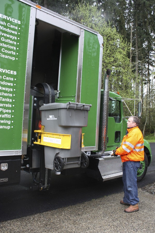 Steam & Clean chief technology officer Jim Morrison operates the company's truck to clean an empty trash bin. The company was founded by Emily Wiewiorka (not pictured)