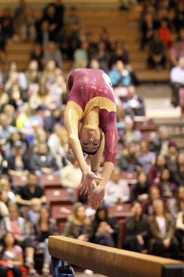 Seattle Pacific University senior Alexa Okamura flies off the balance beam during a meet this season.