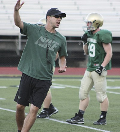 Redmond High head football coach Jason Rimkus leads his team through a practice in 2014.