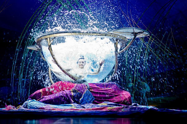 A Cirque du Soleil member performs in the water bowl