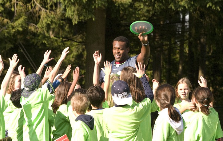 Seattle Seahawks Anthony McCoy leads a group of students at Emily Dickinson Elementary School in Redmond in a game of capture the flag. The tight end's visit was part of the team's Play 60 Tuesdays program