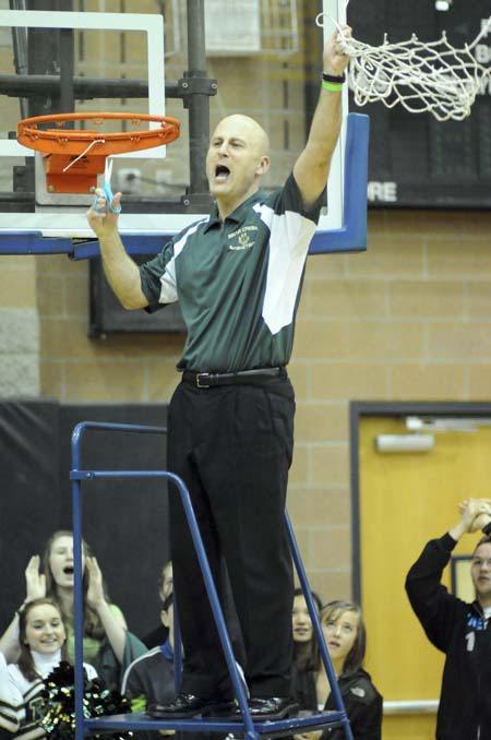 The Bear Creek School boys' basketball coach Scott Moe cuts down the net and celebrates after the top-ranked Grizzlies knocked off Chief Leschi