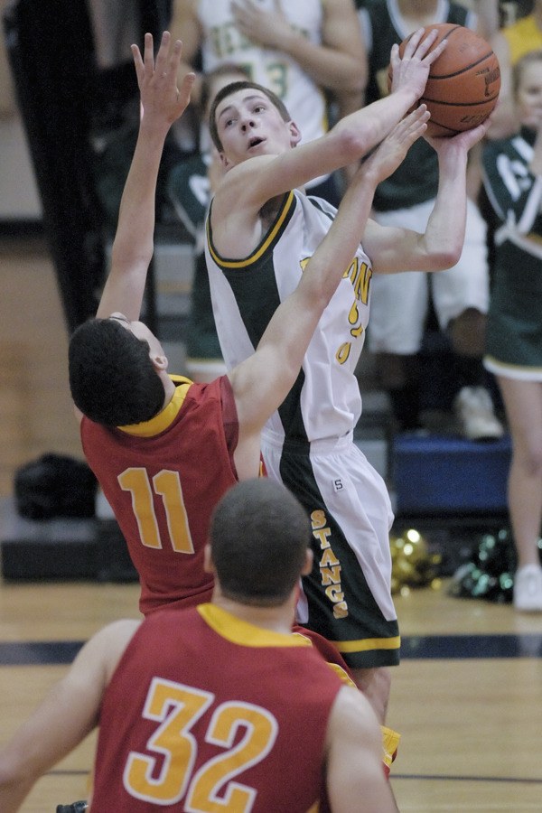 Redmond senior Andrew Squires goes up in traffic against Newport senior Drew Caraway on Tuesday night in the consolation semifinals of the 4A Kingco Tournament. The Mustangs missed a game-winning layup at the buzzer