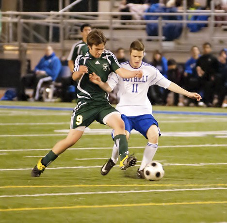 Redmond's J.T. Newton battles for the ball with Bothell senior Brandon Rise during Tuesday night's 4A Kingco soccer game against the Cougars. The Mustangs got shut out