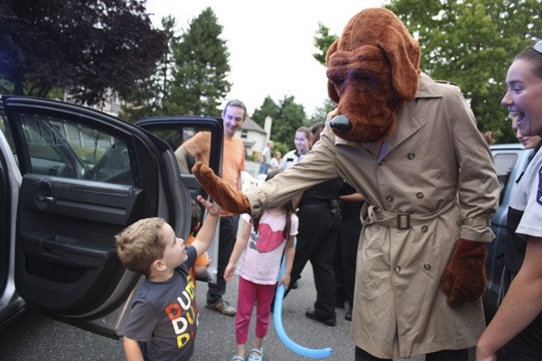 Three-year-old Greyson Callahan gives it to McGruff up top at this year's National Night Out event. This year's event had a record 49 parties in Redmond with about 2
