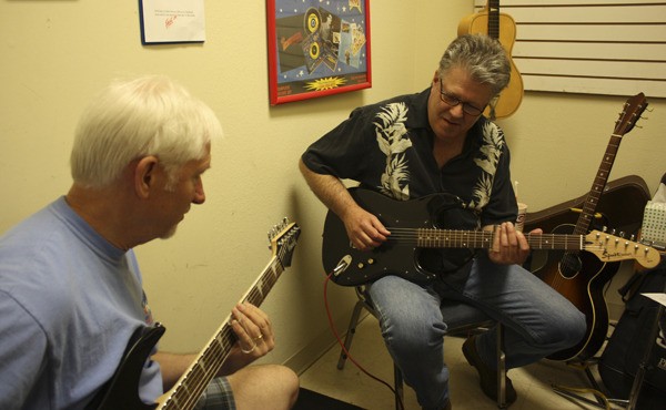 Redmond resident Tom Miller (left) and his instructor Mark Riley jam for a few minutes before starting their formal slide guitar lessons at Pacific Music. Riley was recently named Acoustic Blues Guitarist of the Year for 2012 by the Washington Blues Society.