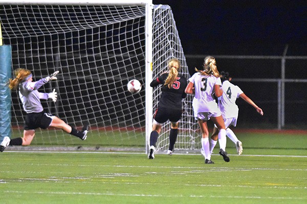 Redmond's Andrea Dang (4) tallies the winning goal in the Mustangs' 2-1 overtime win over Mount Si on Tuesday night. Redmond's Elly Yochum (3) is also pictured.