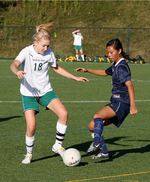 Overlake senior midfielder Emily Kelly battles for the ball against a Cedar Park defender during Tuesday night's 4-2 win over the Eagles. Kelly scored a hat trick