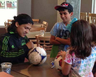 Young Seattle Sounders FC  soccer fans enjoy spending some time with star player Fredy Montero on Monday at Top Pot Doughnuts in Redmond. About 100 people showed up to have Montero sign their T-shirts