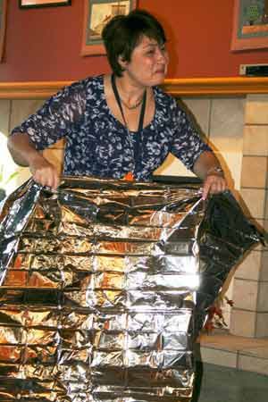 Janeen Olson rolls out a foil heat-reflective survival wrap last Friday at the Redmond Senior Center.