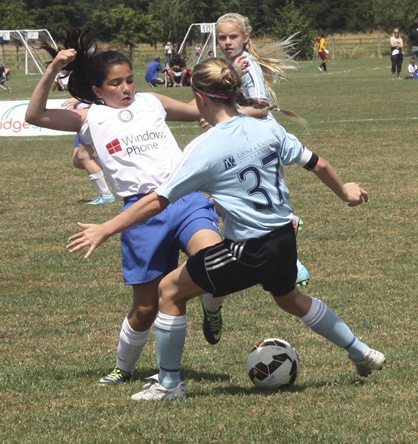 A Redmond-based Crossfire Premier player (left) battles a Seattle United player for the ball this afternoon in a U12 match at 60 Acres North in Redmond. This match was part of the Nike Crossfire Challenge