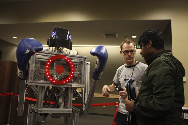 Clint Rutkas of Microsoft (left) and Abhishek Sangameswaran of LWSD STEM School discuss the inner workings of the 'Boxing Bot.'