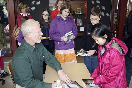 Guest author Ben Mikaelsen signs a copy of his book for Rosa Parks fourth-grader Michelle Yang (right) during a Young Author's event at Benjamin Franklin Elementary School in Kirkland last Saturday. Nearly 300 students from the Lake Washington School District attended the event