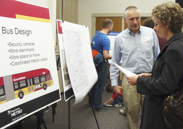 King County Metro Transportation Planner III Jack Whisner talks to a concerned bus rider in front of the display board for the RapidRide bus at last Thursday's public meeting at the Old Redmond Schoolhouse. Metro revealed its proposed changes to local bus services at the meeting. Janelle Kohnert