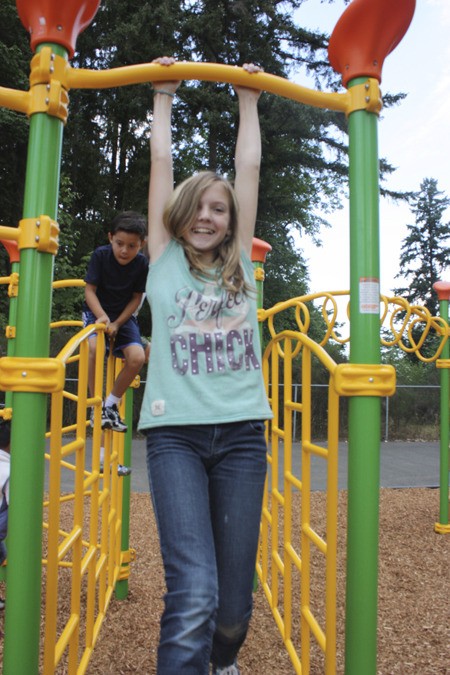 Sixth-grader Katie Chalmers enjoys some hang time with Albert Einstein Elementary School's new playground structure. As a member of the student council