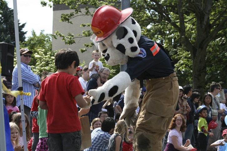 Sparky the Fire Dog offers candy to a young boy during Saturday’s Derby Days Grand Parade.