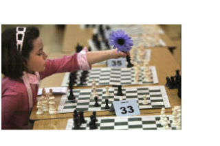 Noelle Kramer holds a flower pen as she makes a move during a chess match with Terrance Li at The Bear Creek School Chess tournament earlier this month.