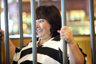 LEFT: Gina Baker tries to talk a friend into giving a donation to help “bail” her out of the Muscular Dystrophy Association’s lock-up event at Claim Jumper last Friday. Each volunteer was given the goal of raising $2