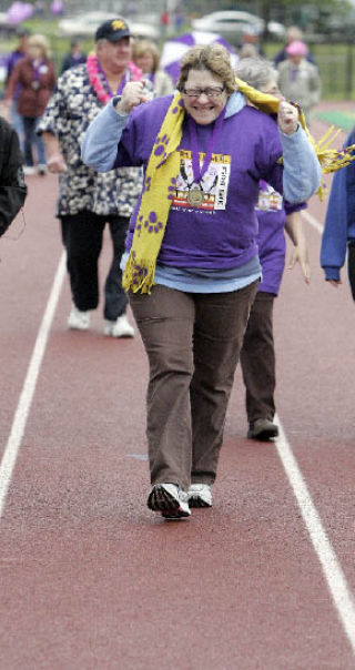 Two-time breast cancer survivor Vickie Mason celebrates while walking with others on the Survivor Lap at the American Cancer Society’s Redmond/Kirkland Relay for Life at Redmond High School last Saturday. For more photos
