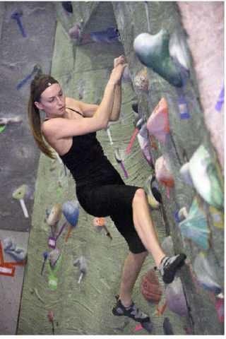 Elena Klions works on bouldering skills along one of the many indoor climbing walls at Vertical World last week. The REI store in Redmond Town Center also has a rock climbing facility.