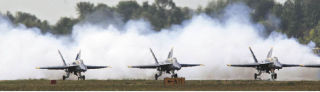 Three of the four Blue Angels begin their takeoff roll at Boeing Field in front of smoke released for dramatic effect. The Blue Angels were part of SeaFair weekend.