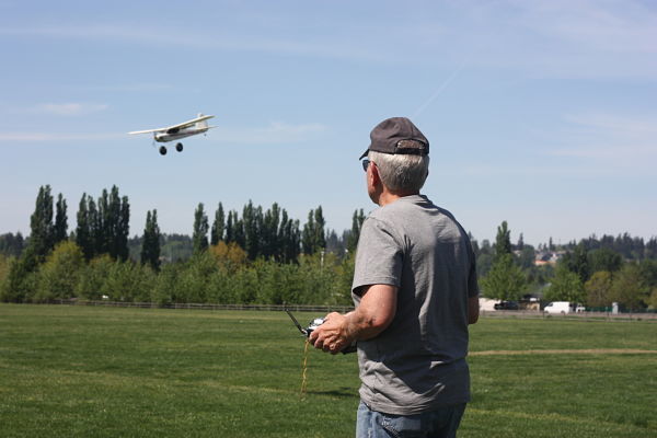Jay Bell of Woodinville soaks up the sun while flying his Fun Cub electric plane Tuesday afternoon at 60 Acres Park in Redmond. Andy Nystrom