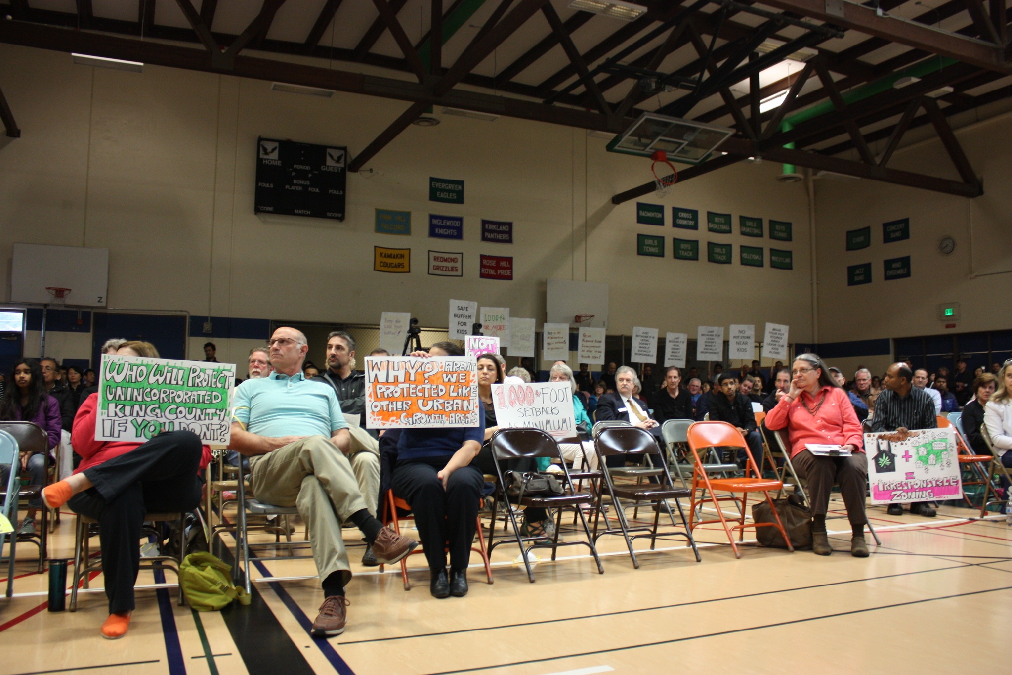 Redmond Ridge residents at a King County town hall hold signs protesting marijuana processing plants in their community. Samantha Pak
