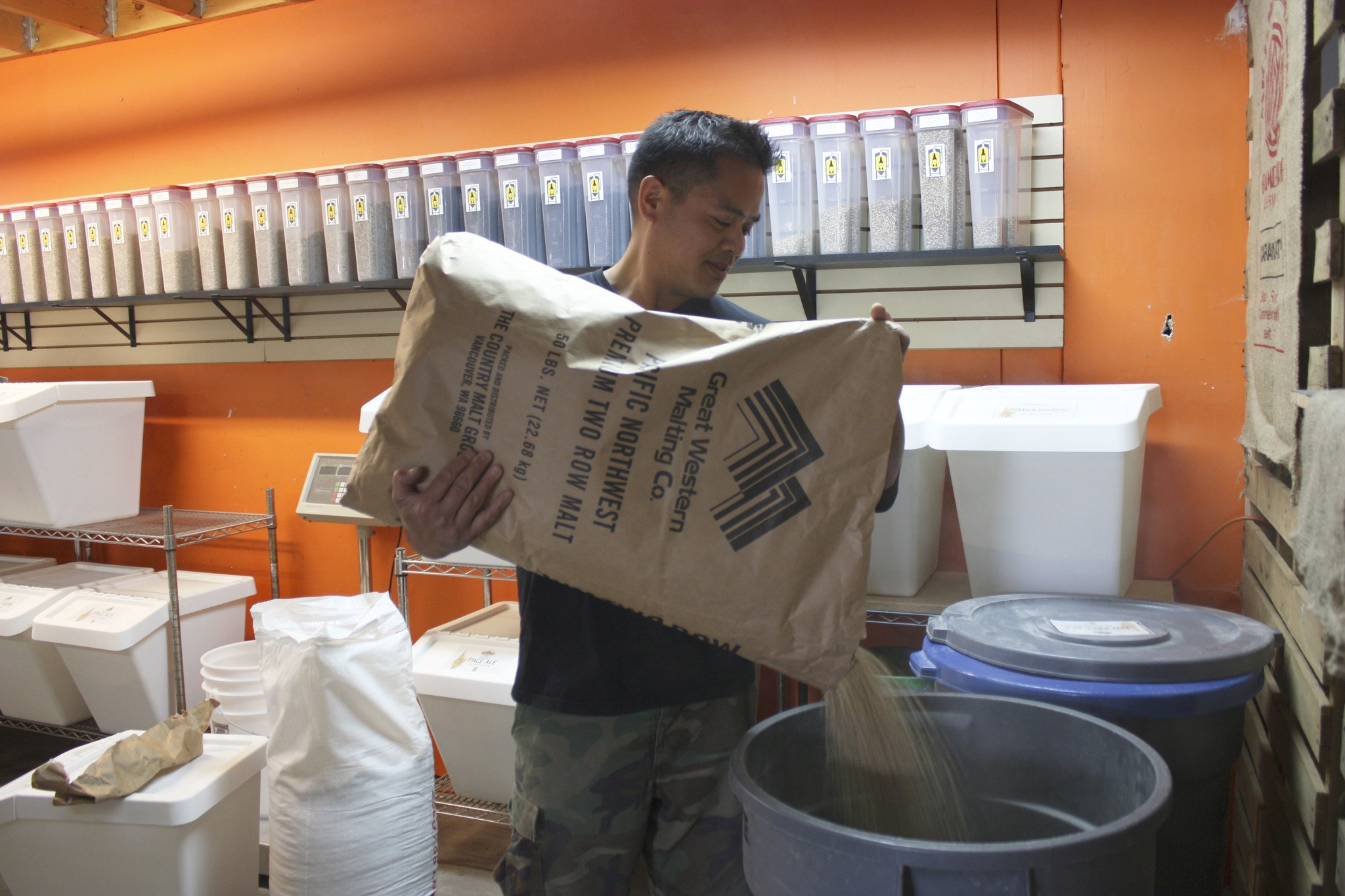 Brewhouse Provisions owner Glenn Rollolazo refills a bin of hops at his Redmond store.
