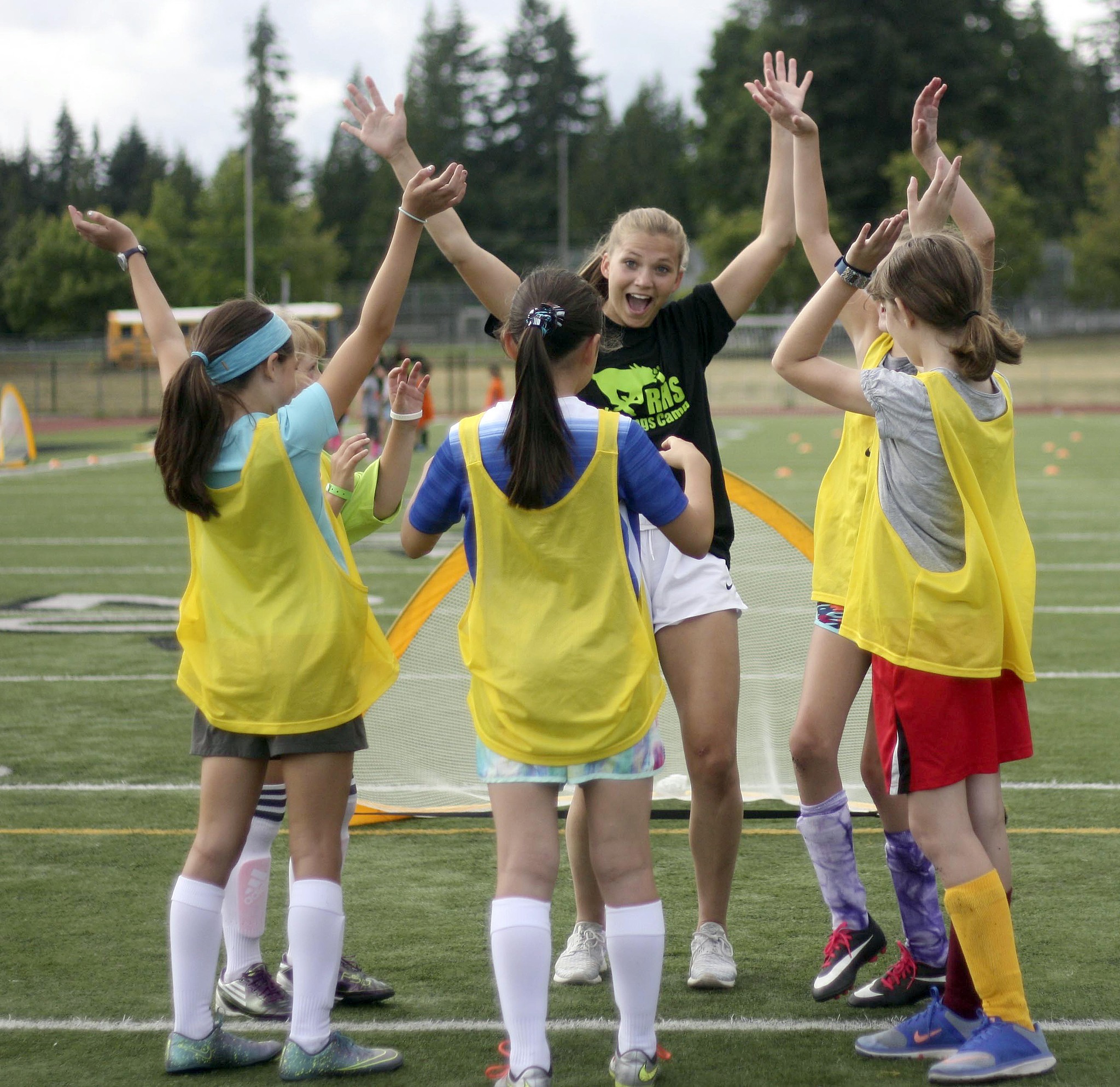 Redmond High varsity soccer player Ellen Hilbun — a senior and captain — lets out a cheer with her Bananas squad during Tuesday’s Jr. Stangs Soccer Camp at the high school. Andy Nystrom