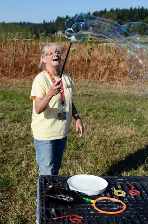 Dr. Maze's Farm employee Teresa Grimm enjoys herself while blowing bubbles for the visitors who came to pick out pumpkins last weekend. The farm is located at 15410 N.E. 124th St. in Redmond.