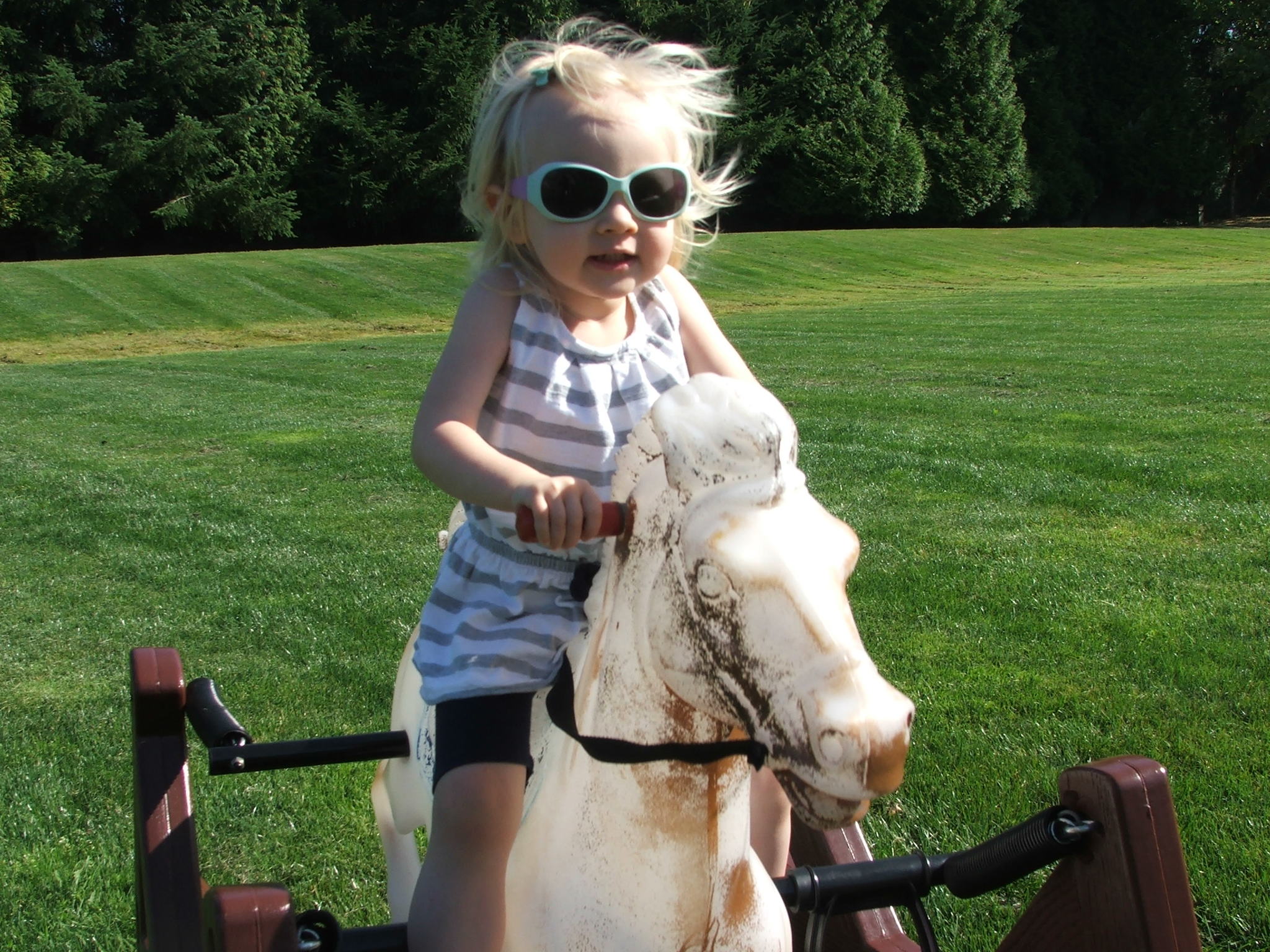 Lily Isenhaur of Redmond rides a toy horse during Kindering’s graduation ceremony and celebration Aug. 16 at Crossroads Park in Bellevue. Courtesy photo