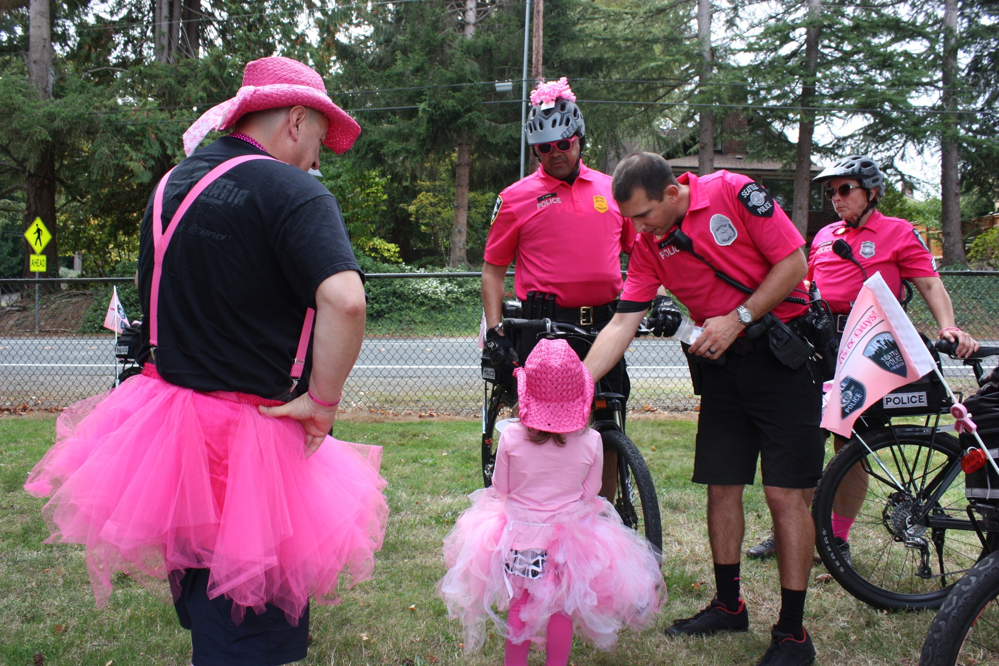 A young girl offers candy to Seattle bicycle police officers to thank them for riding inthe Susan G. Komen 3-Day.