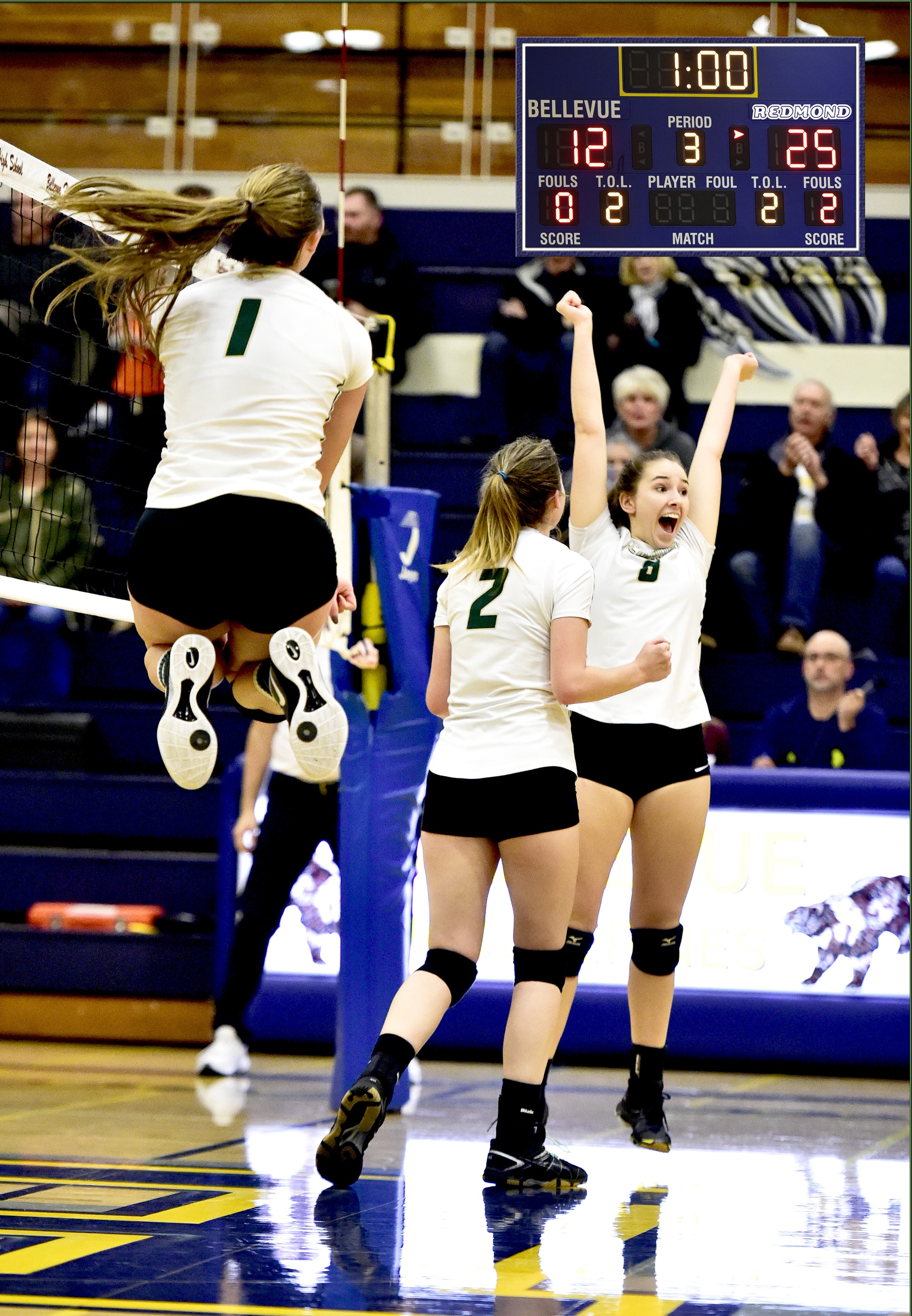 Redmond High volleyball players celebrate during Monday’s victory over Bellevue High. From left