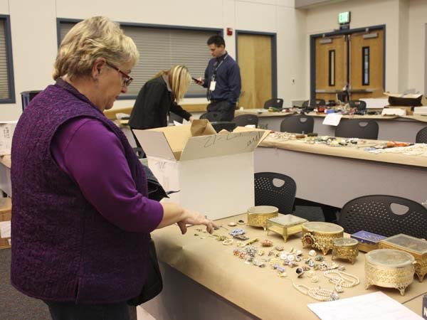 Gail Genereau of Lake Forest Park scours the items recovered from the “Movie Bandits” burglaries on Tuesday at the Redmond Police Department. She found some of her stolen jewelry.