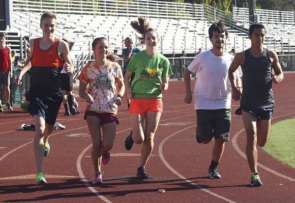 Redmond High cross-country captains jog around the track on Monday. From left