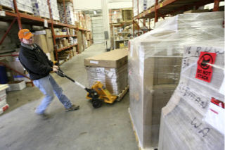 Warehouse manager Charles Jackson pulls a pallet while working in the warehouse at Keeney’s Office Plus