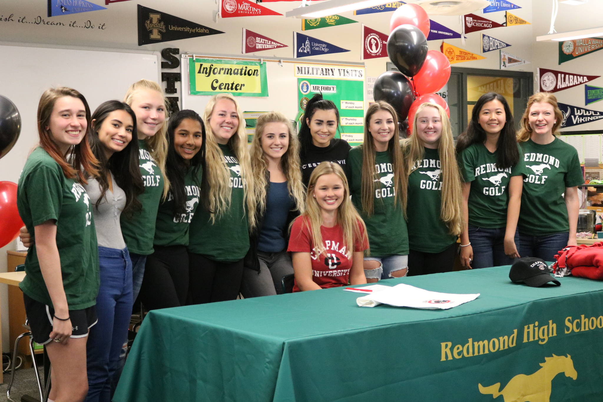 Lauren Settle, sitting, is surrounded by her Redmond High golf squad and coach Maggie Chambers, far right. Andy Nystrom, Redmond Reporter