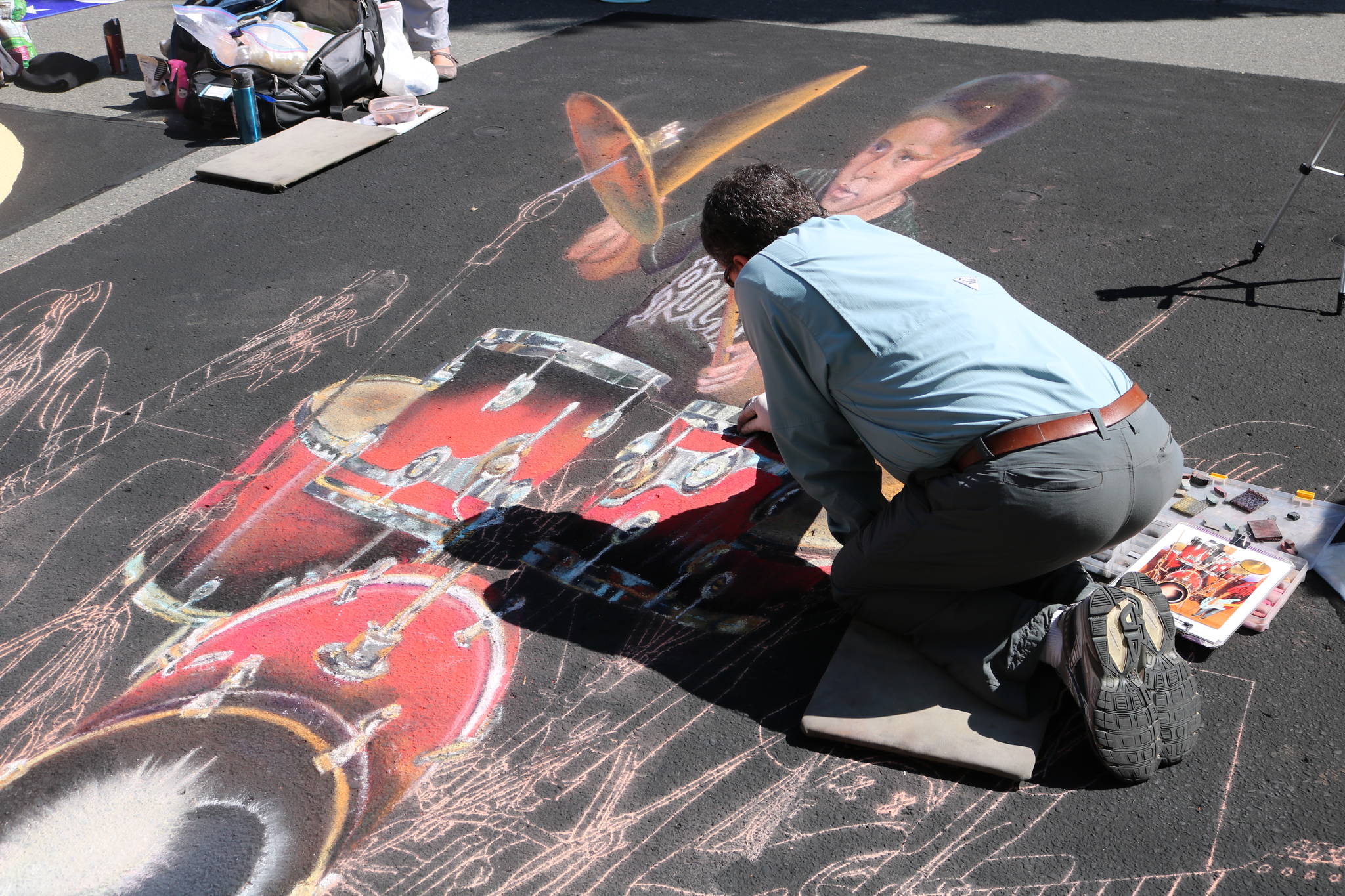 Wayne and Cheryl Renshaw shared credit for their chalk art creation that was on display at the Pacific NW Chalk Fest last weekend. Wayne Renshaw can be seen here drawing their picture last Saturday. Aaron Kunkler/Redmond Reporter