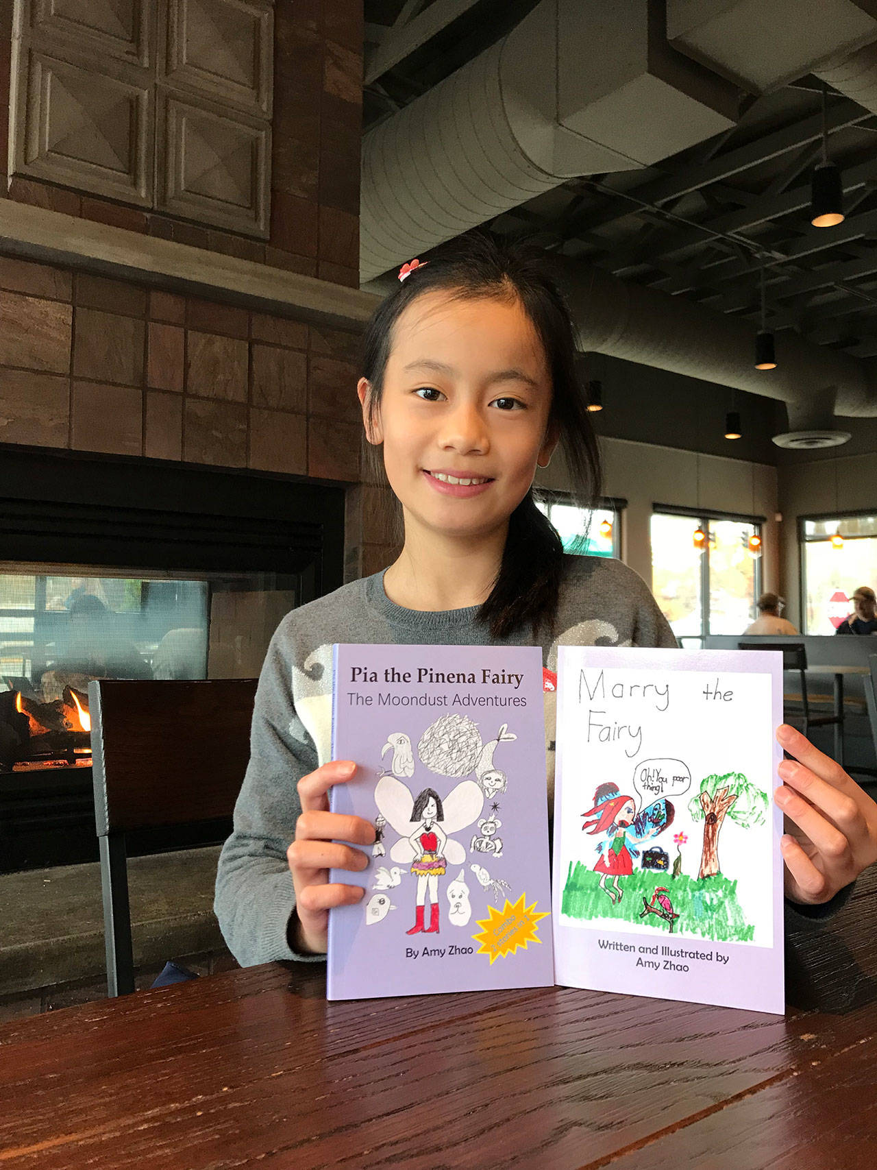 Amy Zhao shows off two of her books. The 9-year-old has published four books following her fairy characters. Samantha Pak, Bothell/Kenmore Reporter