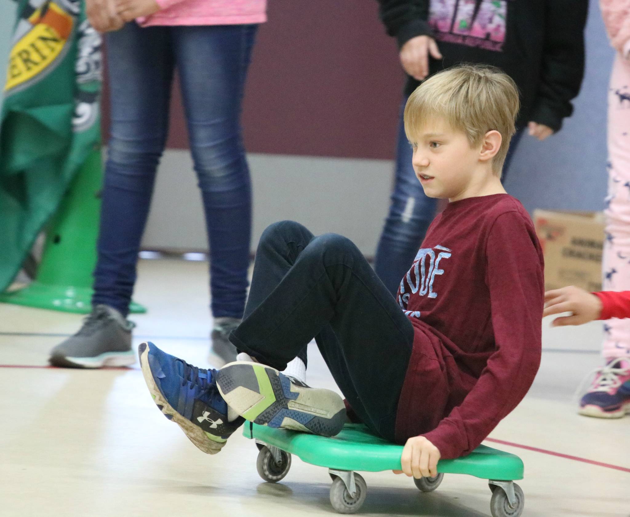 Fifth-grader Walter Kelley rolls across the gym floor during the curling event. Kelley and Rodriguez were teammates on the Slytherin squad. Andy Nystrom, Reporter