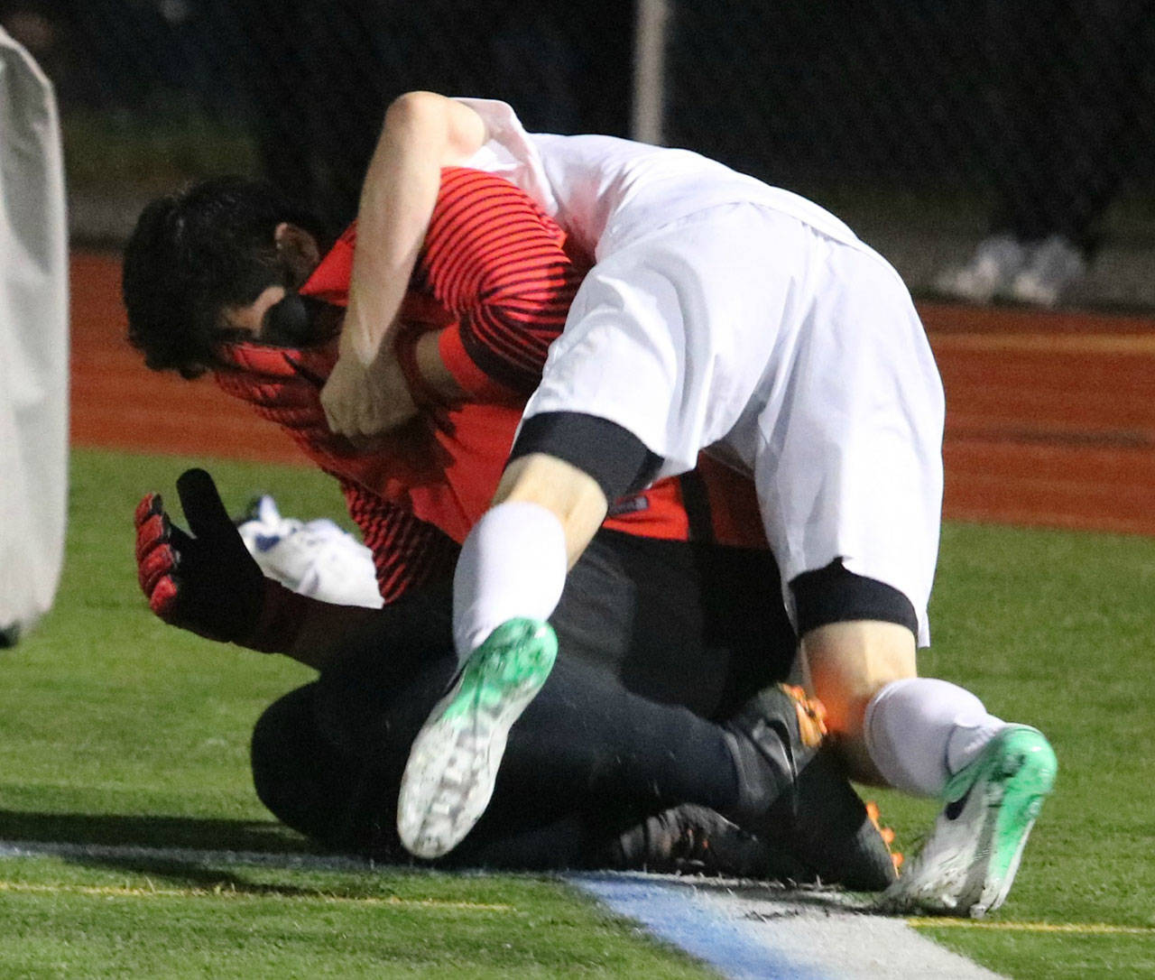 A Redmond player embraces Mustang goalkeeper Ricardo Escalante following the squad’s penalty kick win. Andy Nystrom / staff photo