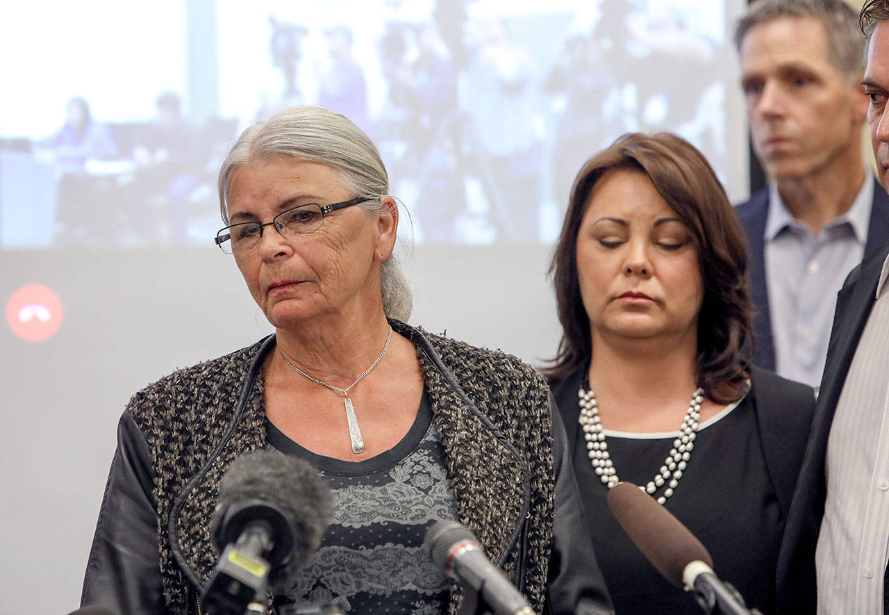 Lee Cook (left) and Laura Baanstra (second from left) at a news conference Friday in Everett, where two county sheriffs announced the arrest of a suspect in the 1987 slayings of Jay Cook, 20, and his girlfriend, Tanya Van Cuylenborg. Lee Cook is Jay Cook’s mother, and Baanstra is his sister. (Lizz Giordano / The Herald)